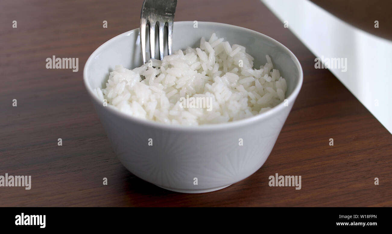 Closeup of woman eating rice from bowl Stock Photo