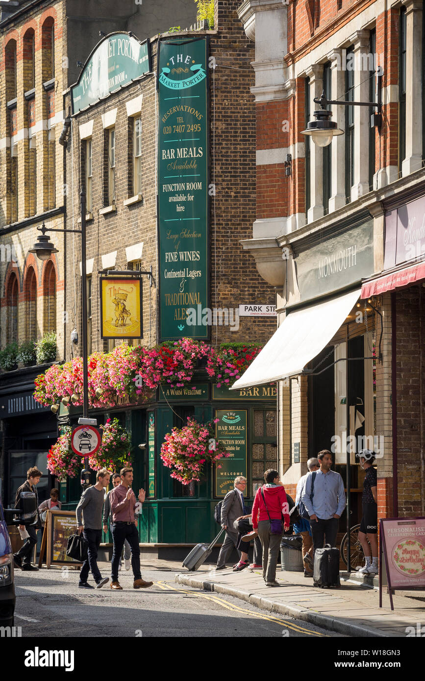 A bright and colourful Stoney Street, London in full summer bloom with the Market Porter traditional public house pub and cake and coffee shops Stock Photo