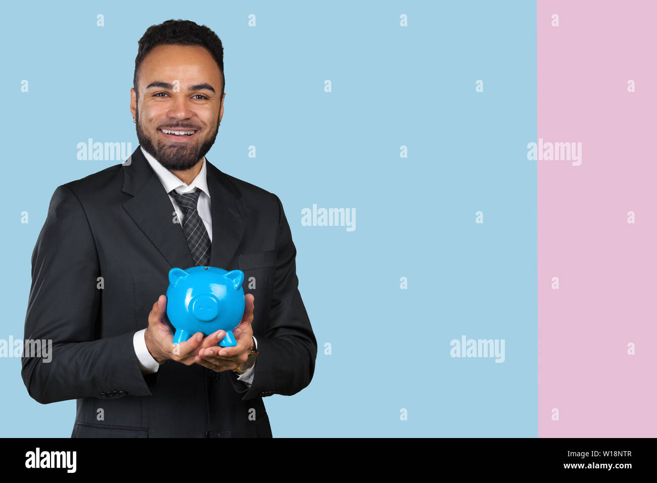 African American business man holding a piggy bank Stock Photo - Alamy