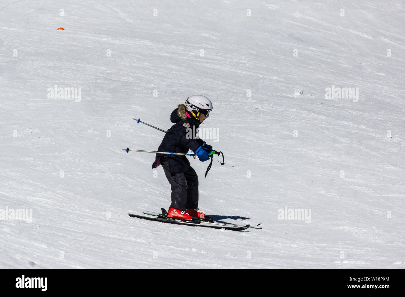 The central Pyrenees at Pont Espagne. Young girl learning to ski on the beginners slope.two sticks. Stock Photo