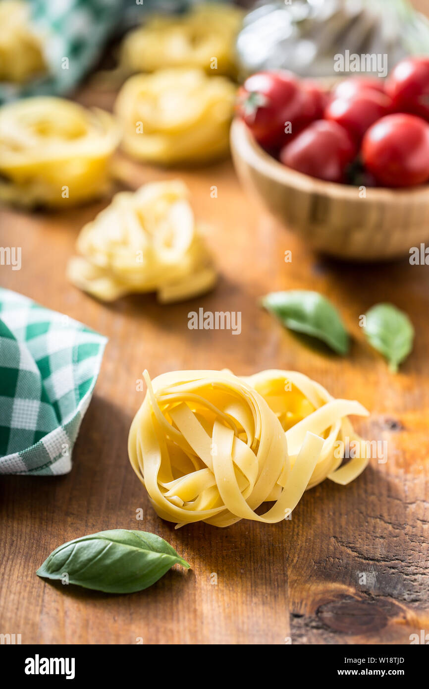 Italian pasta tagliatelle on table with basil and tomatoes Stock Photo