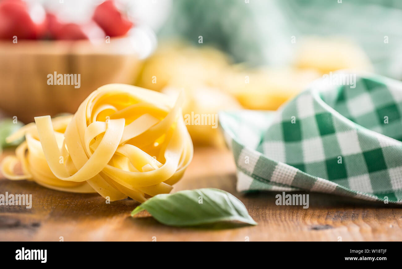 Italian pasta tagliatelle on table with basil and tomatoes Stock Photo