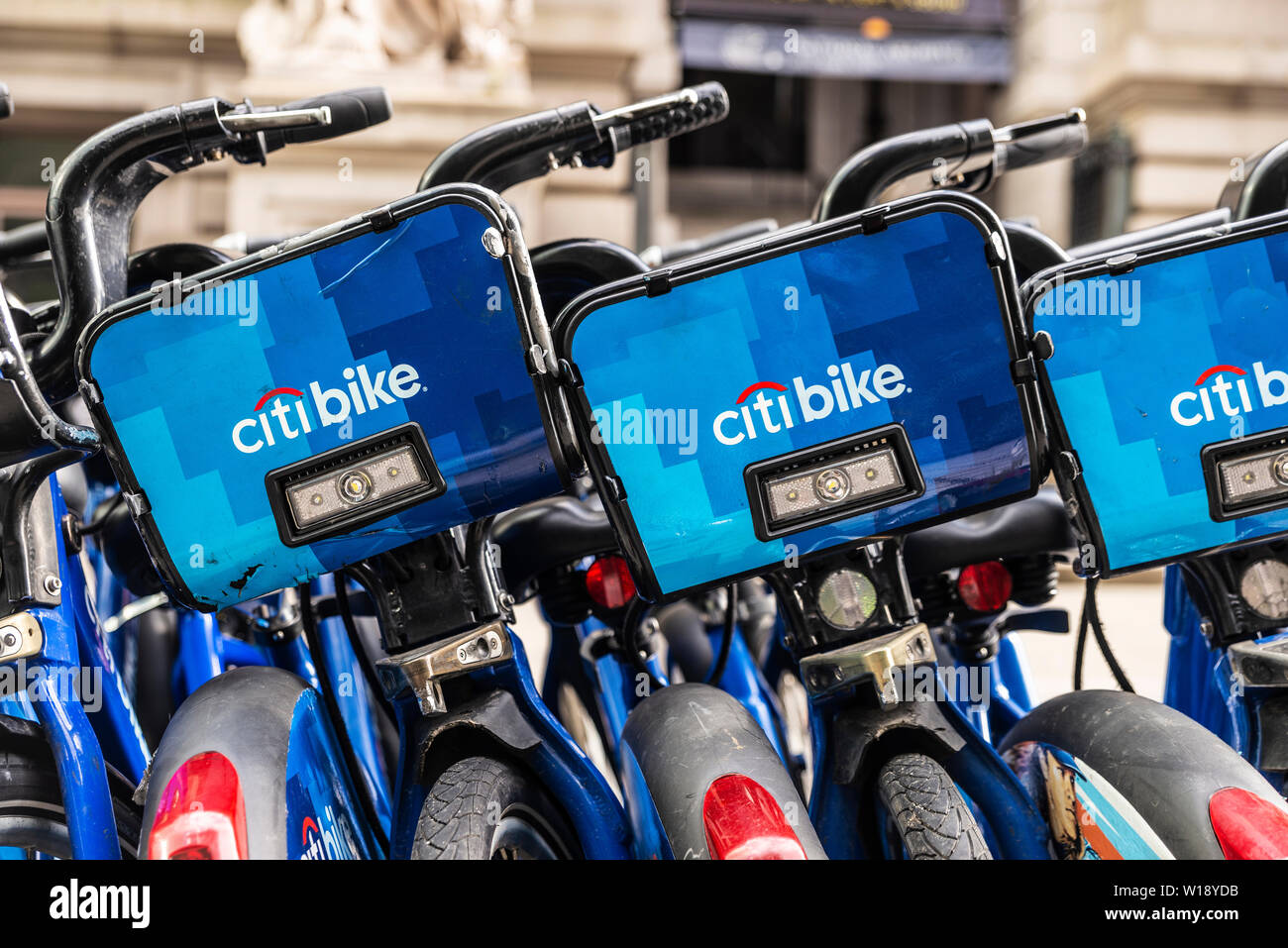 New York City, USA - August 1, 2018: A row of rental bikes with advertising from Citibank in their docking stands on a street in New York City, USA Stock Photo