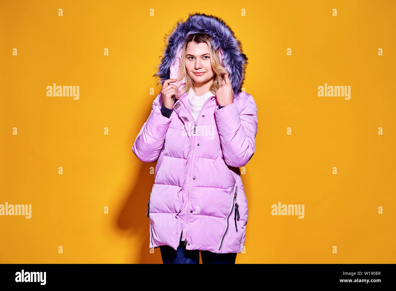Young fashion woman in short violet down jacket. Stock Photo