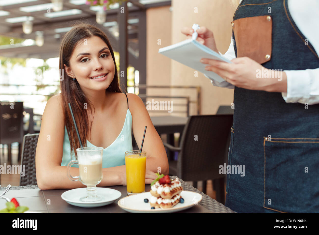 Waitress server helping client in cafe Stock Photo Alamy