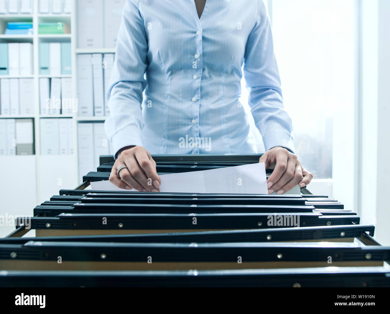 A Woman Filing Documents Into A Cabinet Hi Res Stock Photography And