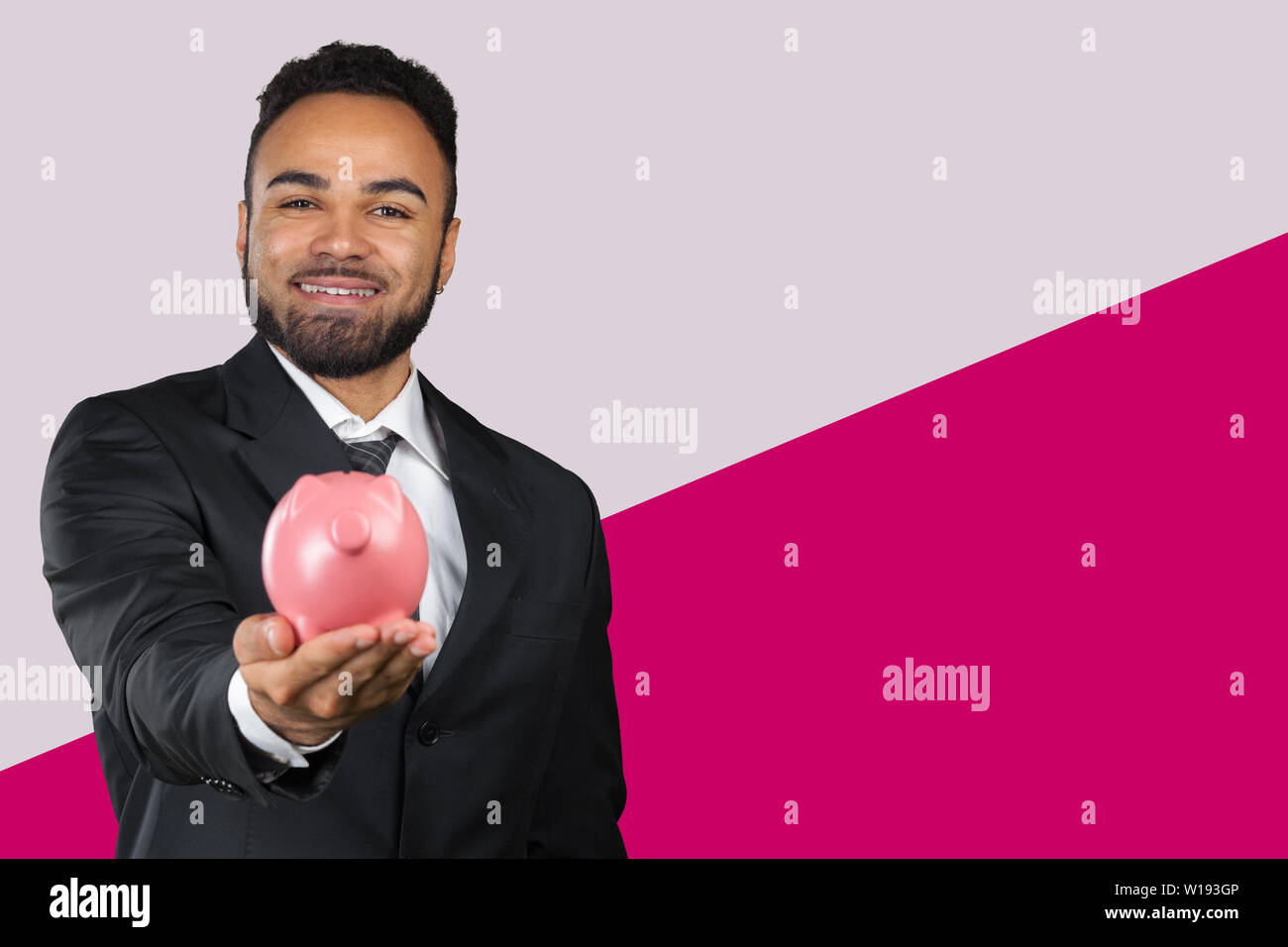 African American business man holding a piggy bank Stock Photo - Alamy