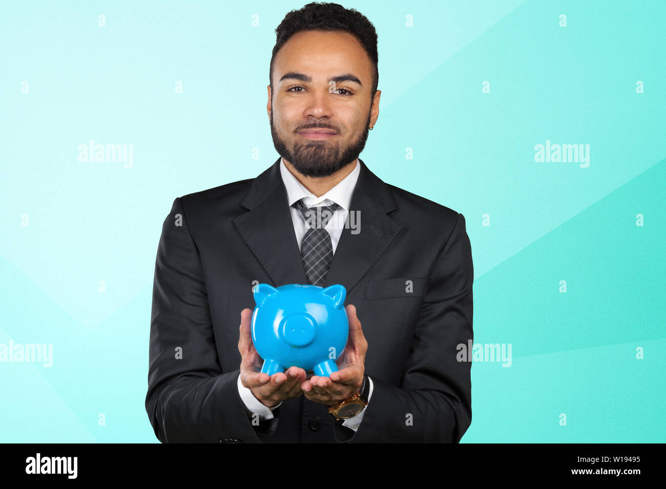 African American business man holding a piggy bank Stock Photo - Alamy