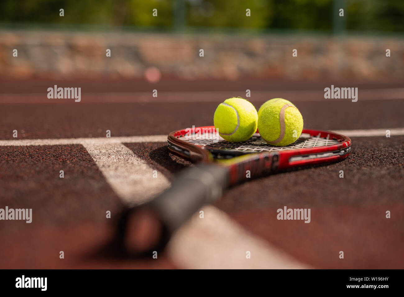 Two balls for playing tennis on racket crossing white line of sports