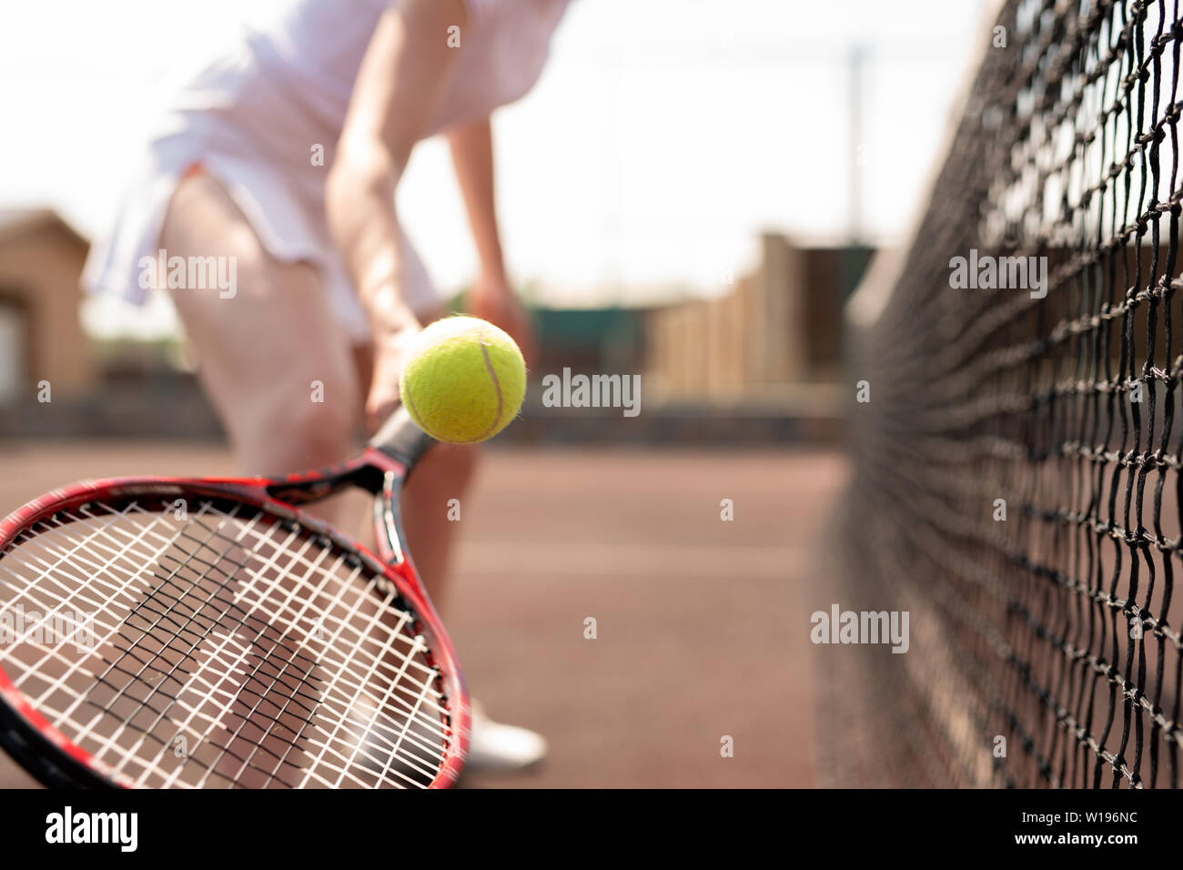 catching tennis ball with racket