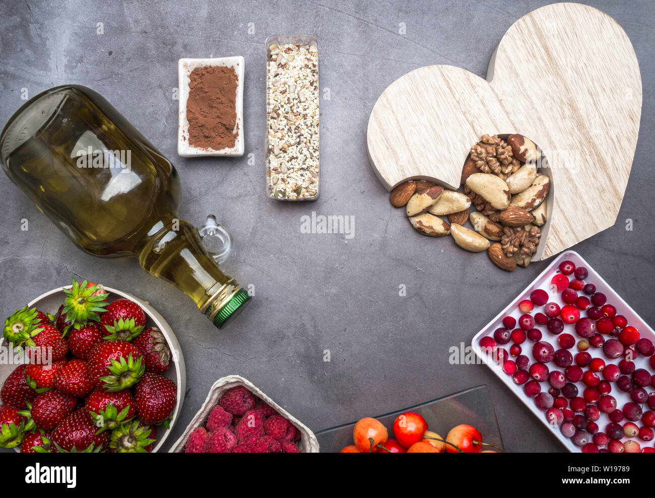 Healthy diet for the cardiovascular system with a wooden heart, seeds, berries, nuts , oil copy