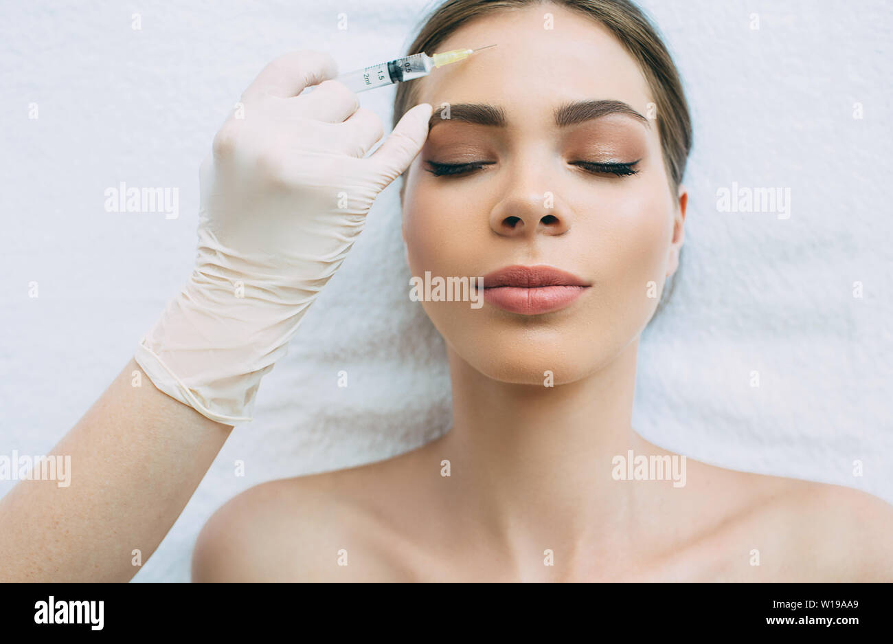 injections in forehead wrinkles, blocking mimic wrinkles using beauty injections at beauty clinic Stock Photo