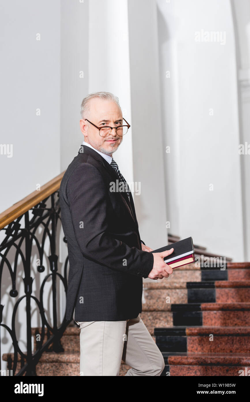 Mature teacher holding glasses hi-res stock photography and images - Alamy