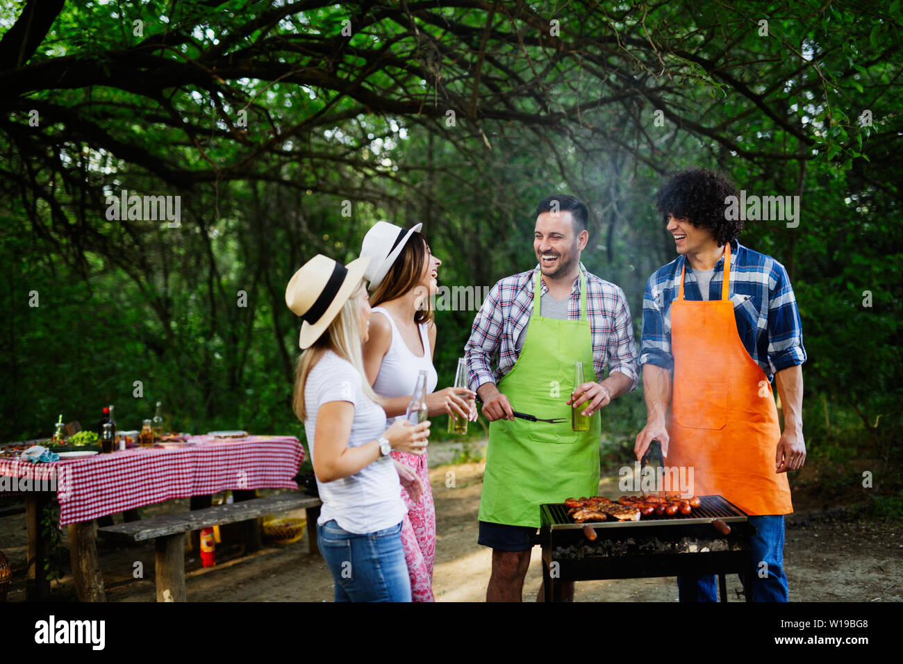 Group of happy friends having a barbecue party in nature Stock Photo ...