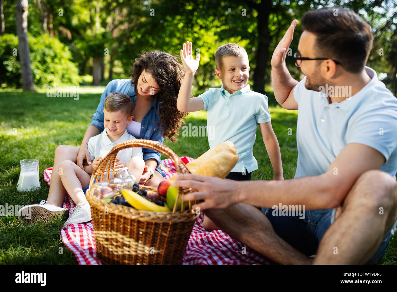 Happy young family enjoying picnic in nature Stock Photo
