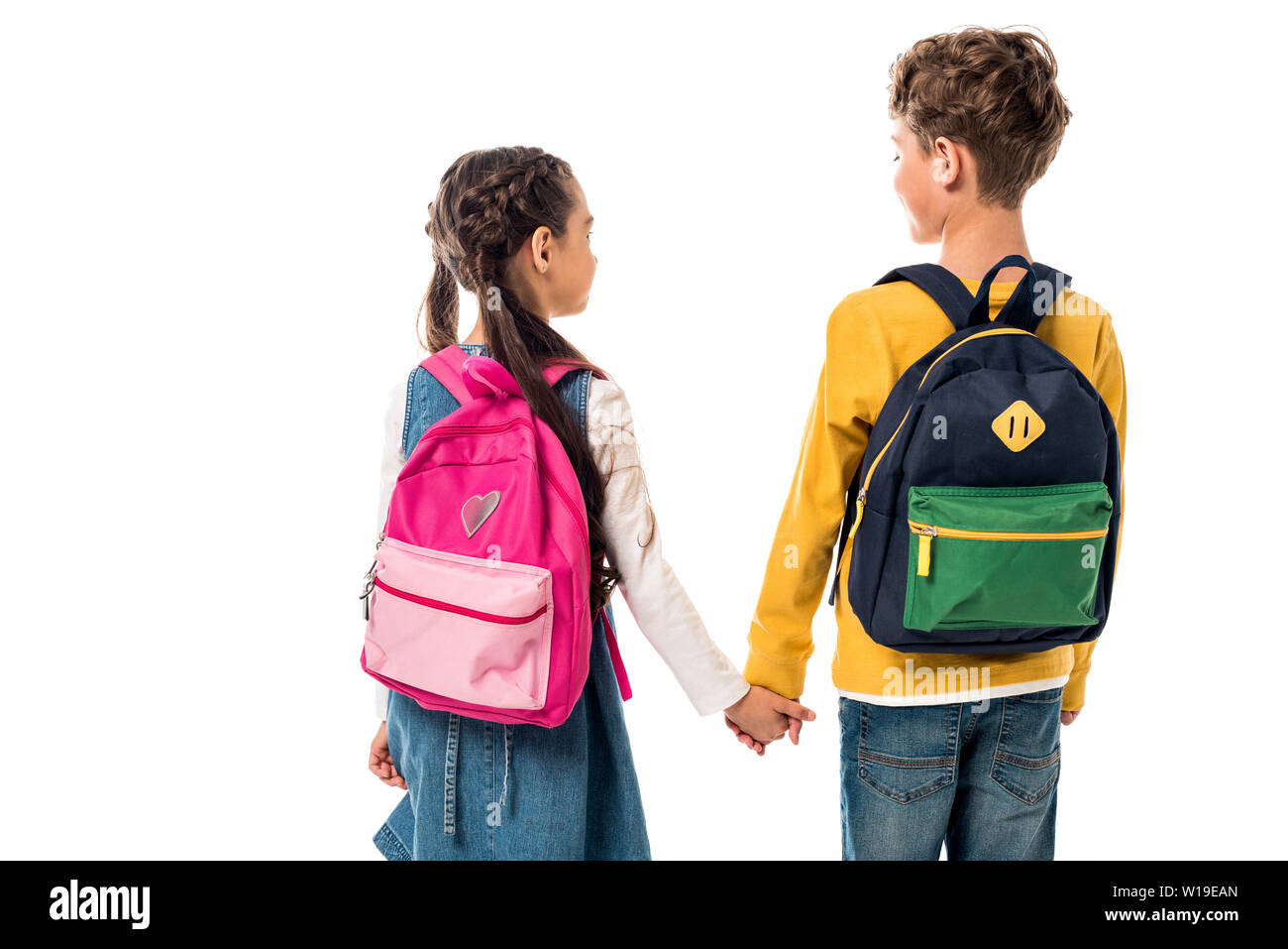 back view of schoolchildren with backpacks holding hands isolated on ...