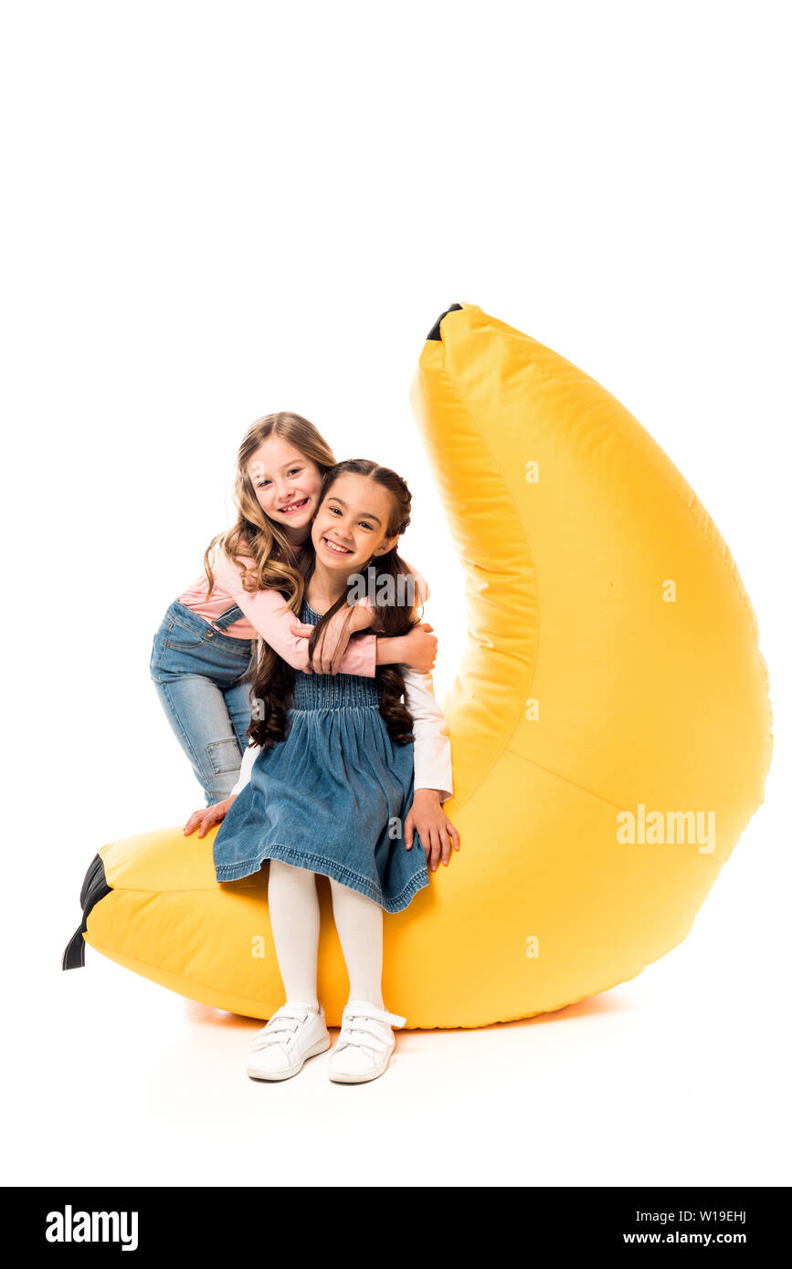 two smiling kids with bean bag chair on white Stock Photo Alamy