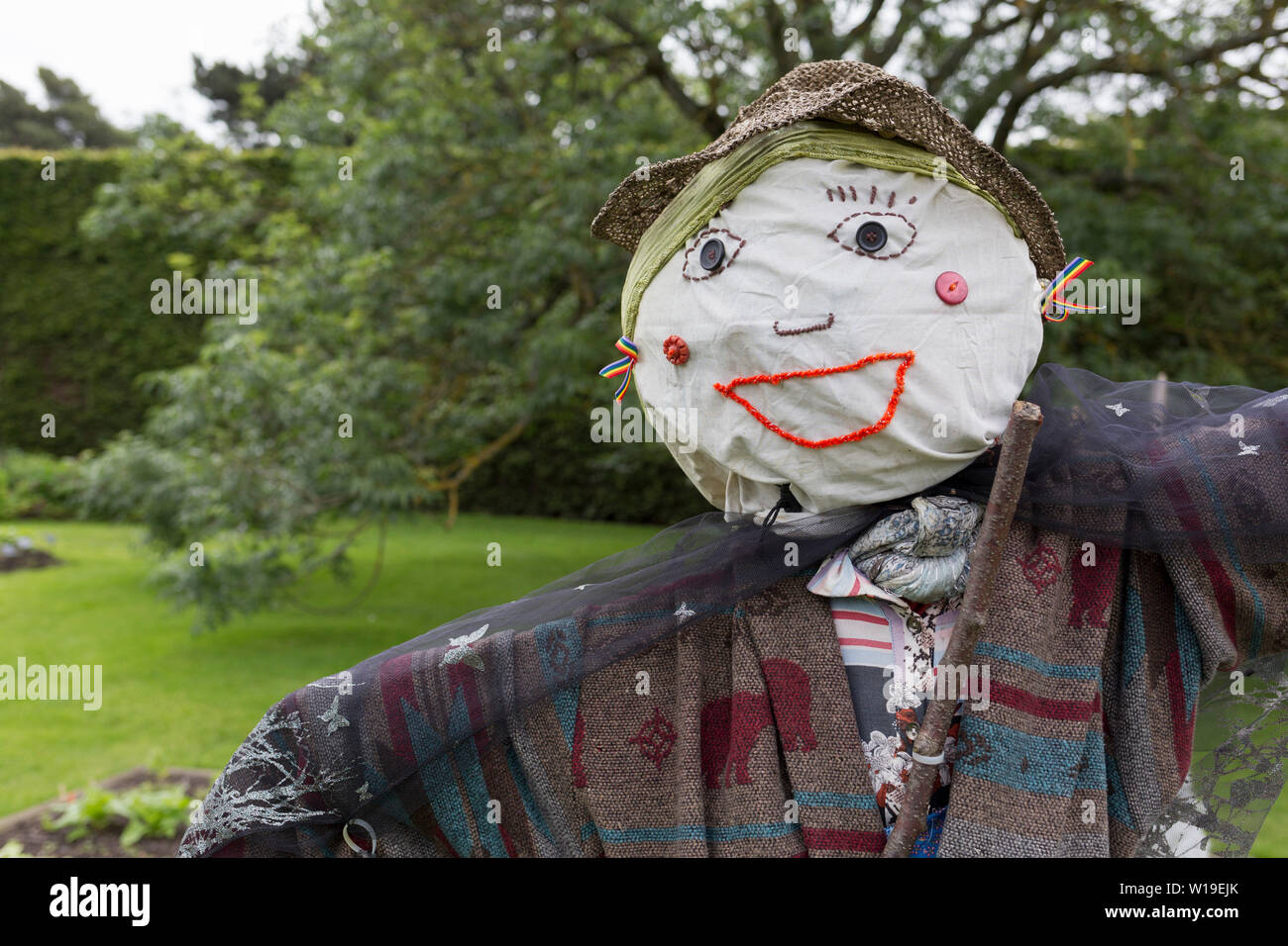 The face of an embroidered scarecrow in a garden at the Royal Botanical Gardens in Edinburgh, on 26th June 2019, in Edinburgh, Scotland. The Royal Botanic Garden Edinburgh (RBGE) is a scientific centre for the study of plants, their diversity and conservation, it was founded in 1670 as a physic garden to grow medicinal plants. Stock Photo