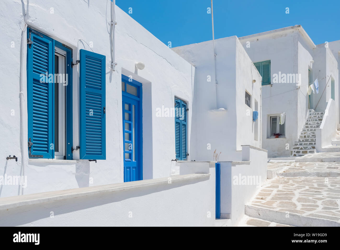 White house facade with traditional blue door on Paros island, Cyclades