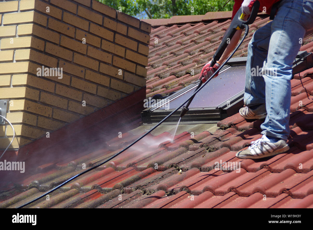 House roof cleaning with pressure tool. Moss removing with water. Tile
