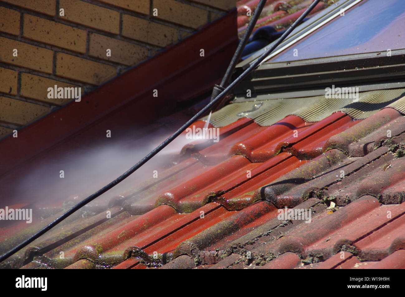 House roof cleaning with pressure tool. Moss removing with water. Tile
