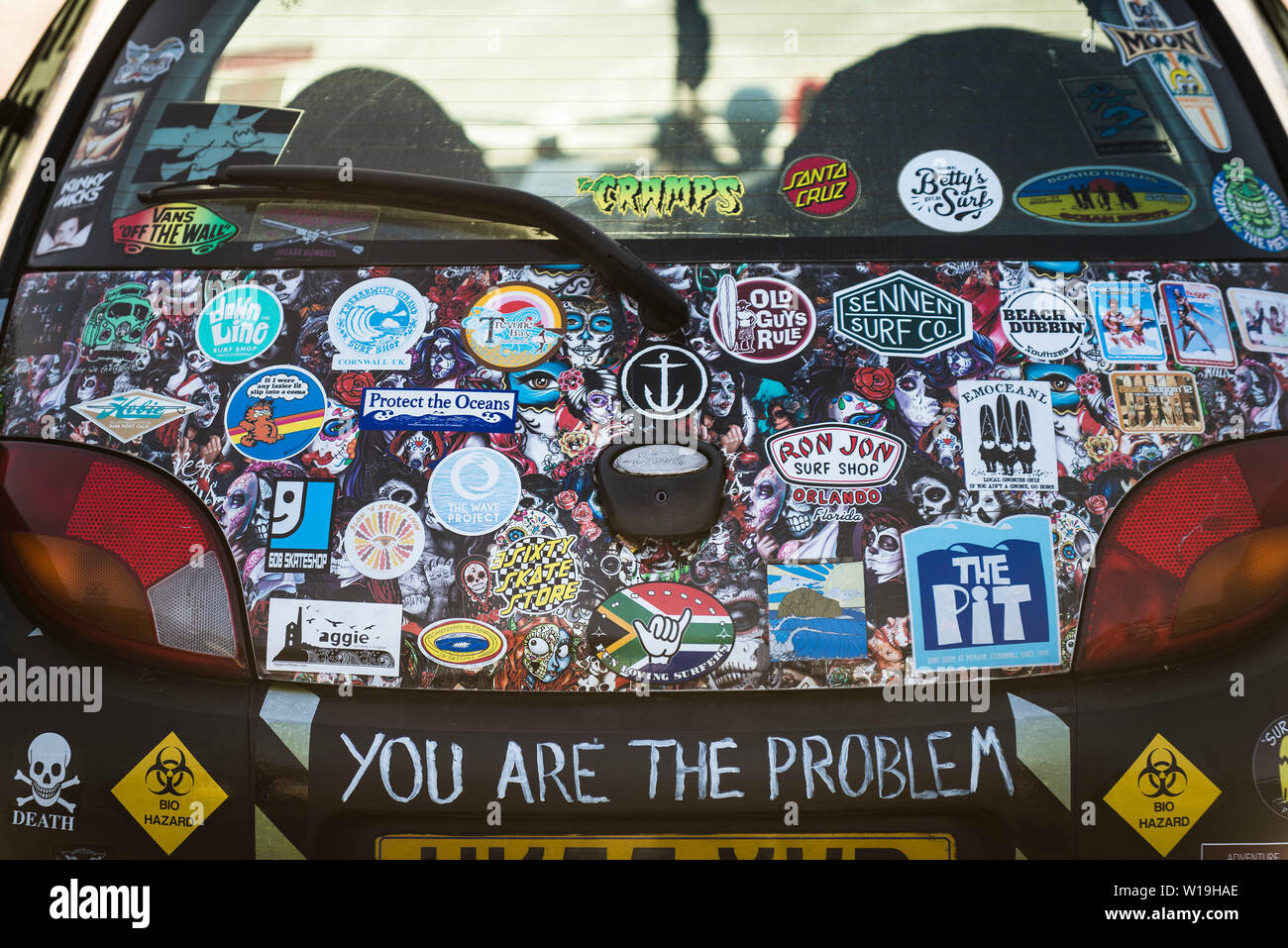 The rear of a Ford motor car covered in various colourful stickers. Stock Photo