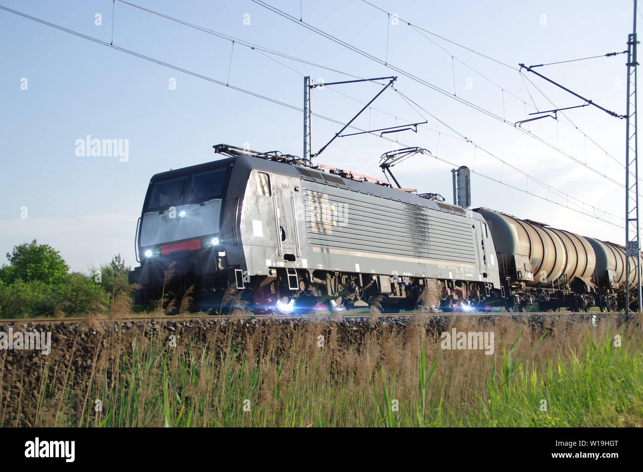 Fast electric train on tracks. Freight railway transport in Europe. Stock Photo