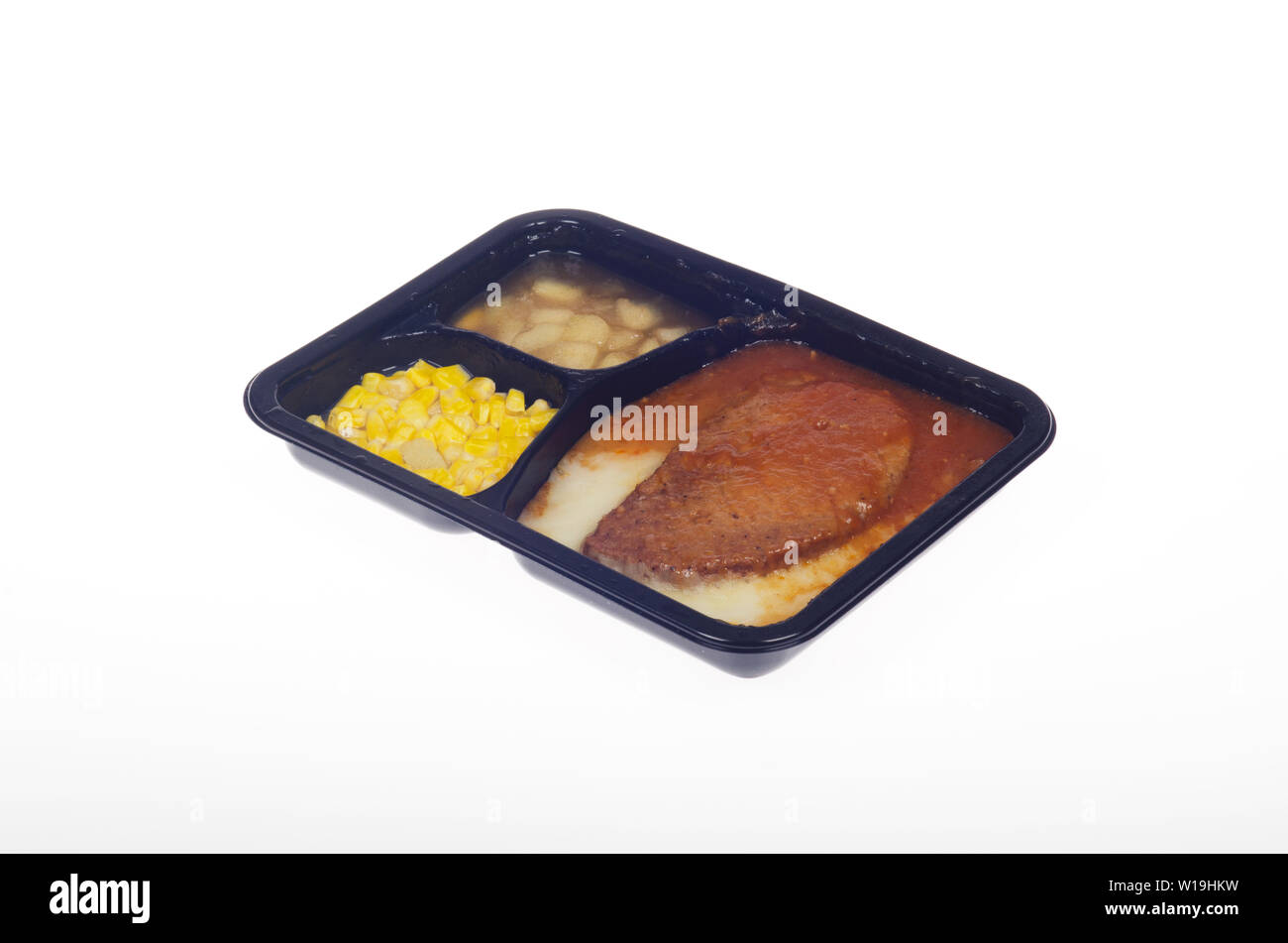 Hot cooked tv dinner in microwaveable tray meatloaf, mashed potatoes, gravy, sweet corn and cinnamon apple dessert Stock Photo