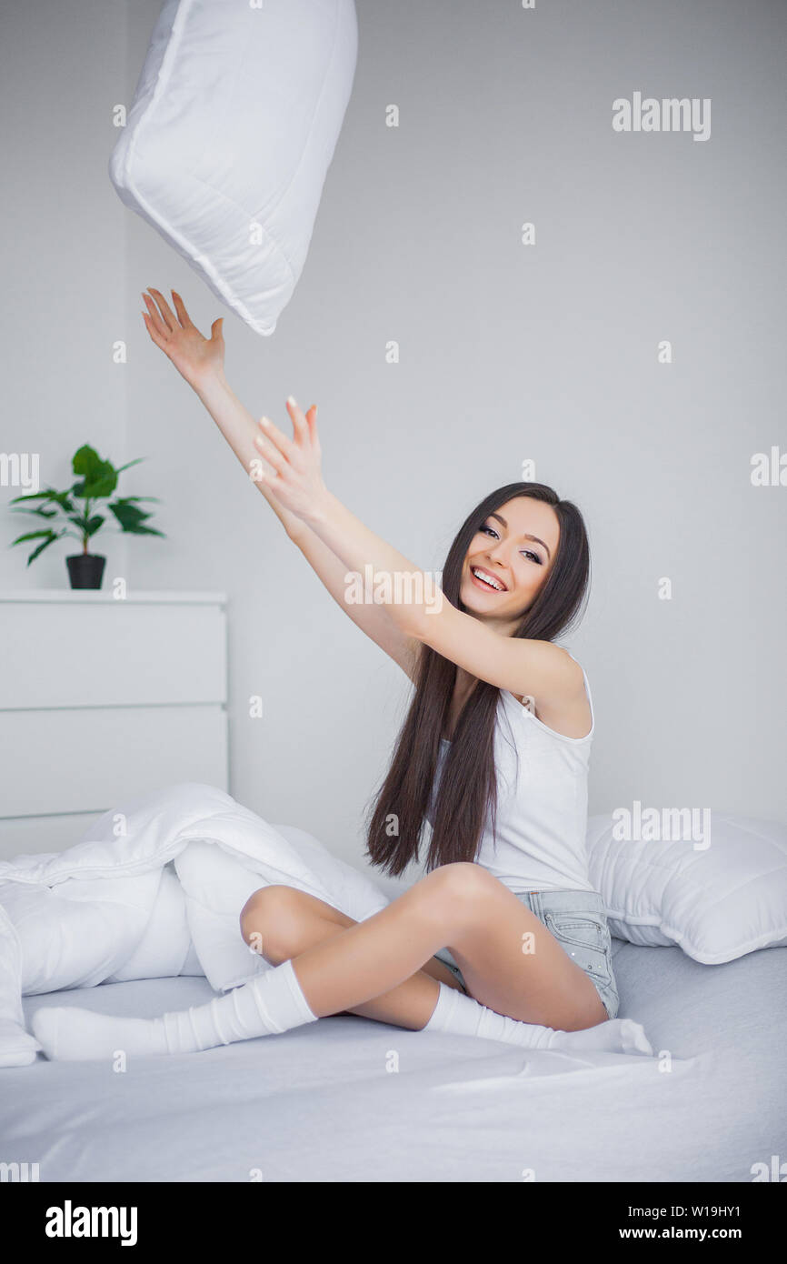 Care Concept. A beautiful young smiling brunette woman lying in white ...