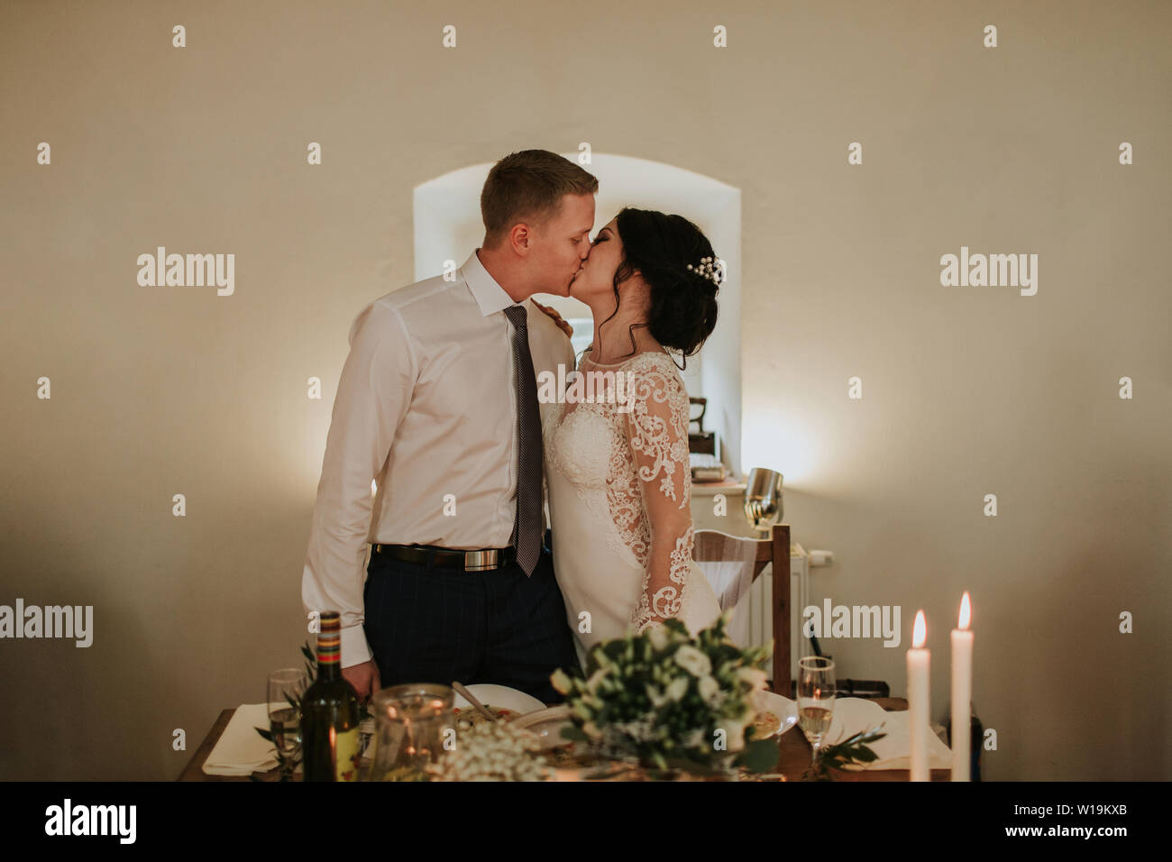 Bride and groom kissing on their wedding day. Just married couple in love sharing tender moments at their wedding party. Stock Photo