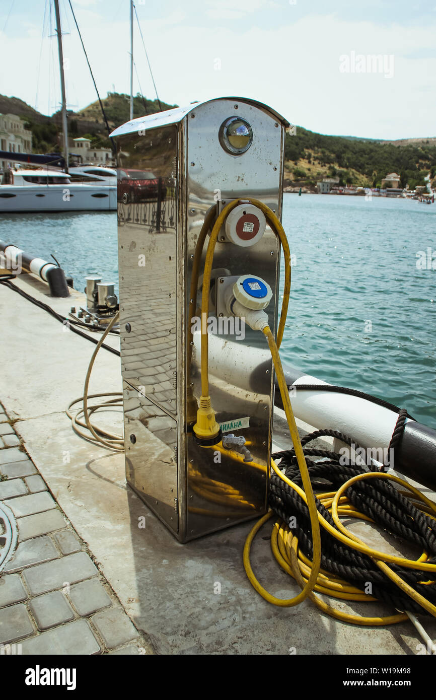 Balaklava, Russia - june 26, 2019: Electricity and water station in yacht harbor. Charging station for boats, electrical outlets in harbor. Electrical Stock Photo