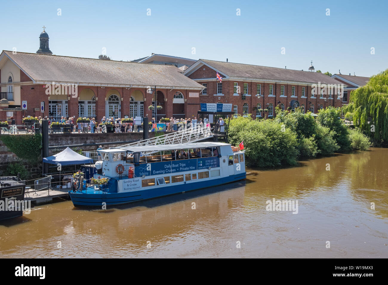 Passengers waiting to board a river cruise boat moored on the River Severn at Victoria Quay in Shrewsbury, Shropshire, UK Stock Photo
