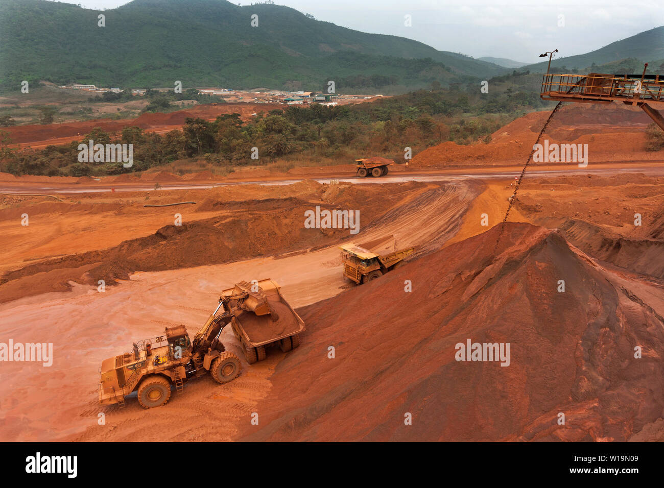 Mining operations for transporting and managing iron ore. From top of lump stacker showing loading fines from fines stacker before train loading. Stock Photo