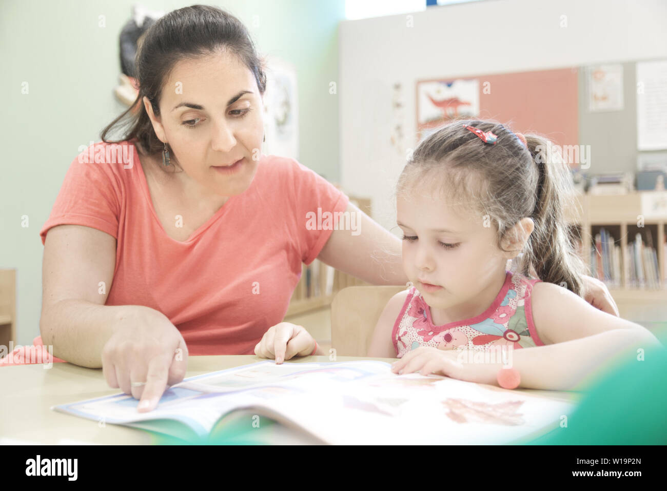 BARCELONA, JUNE 27: Caucasian teacher with a child girl in a reinforcement classroom, Stock Photo