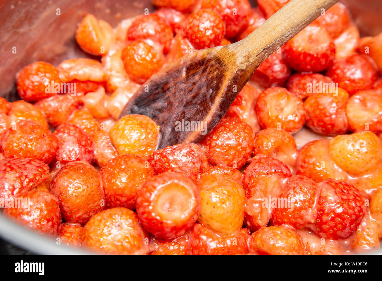 Heating strawberries until they are soft to make strawberry jam on an