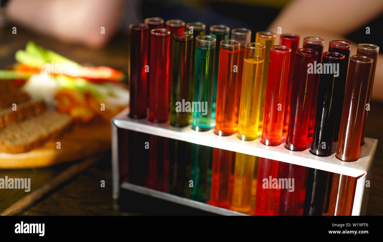 Test tubes with multicolored liquid. Alcohol in test tubes dark bar