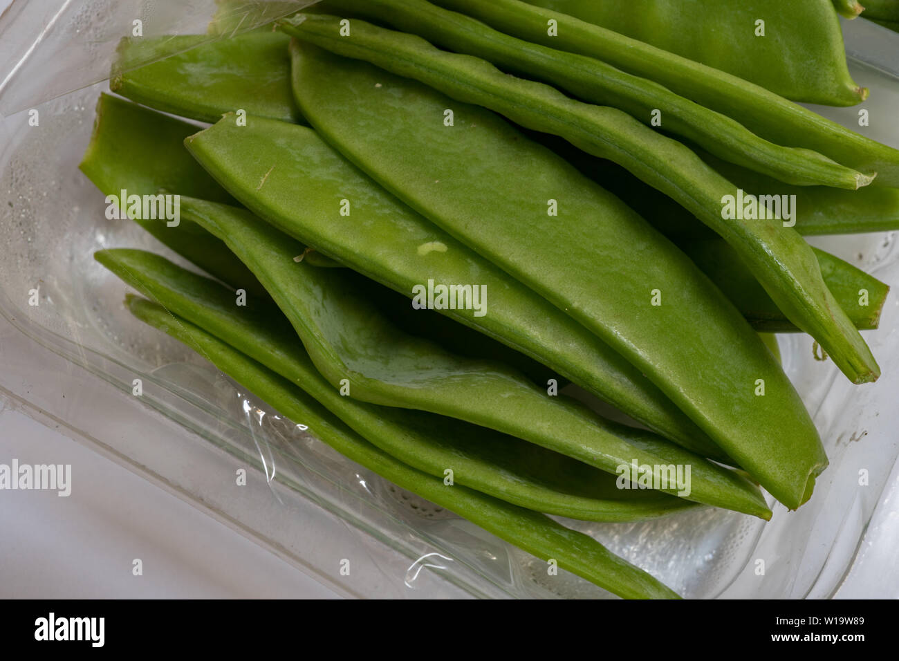 Plastic wrapped Sugarsnap peas, imported from Kenya. UK 2019 Stock Photo