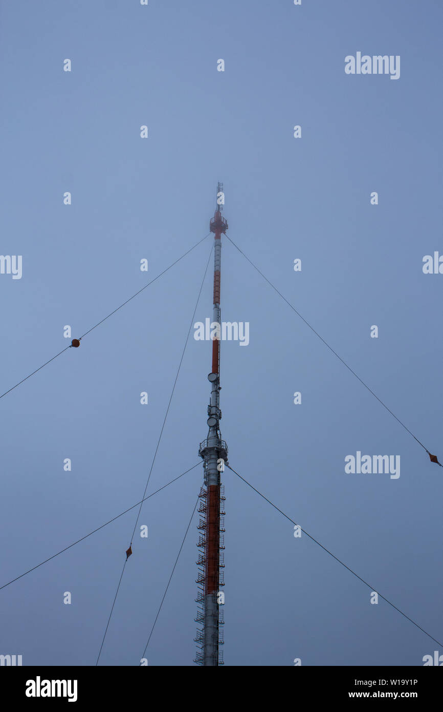 Radio antenna, red and white in misty conditions Stock Photo