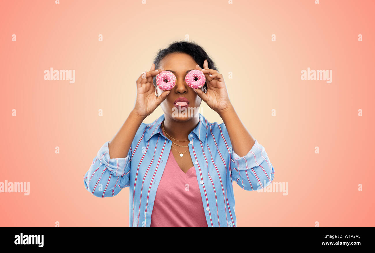 happy african american woman with eyes of donuts Stock Photo