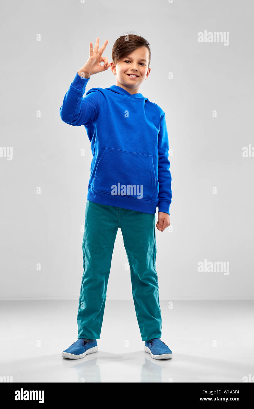 boy in blue hoodie showing ok hand sign Stock Photo Alamy