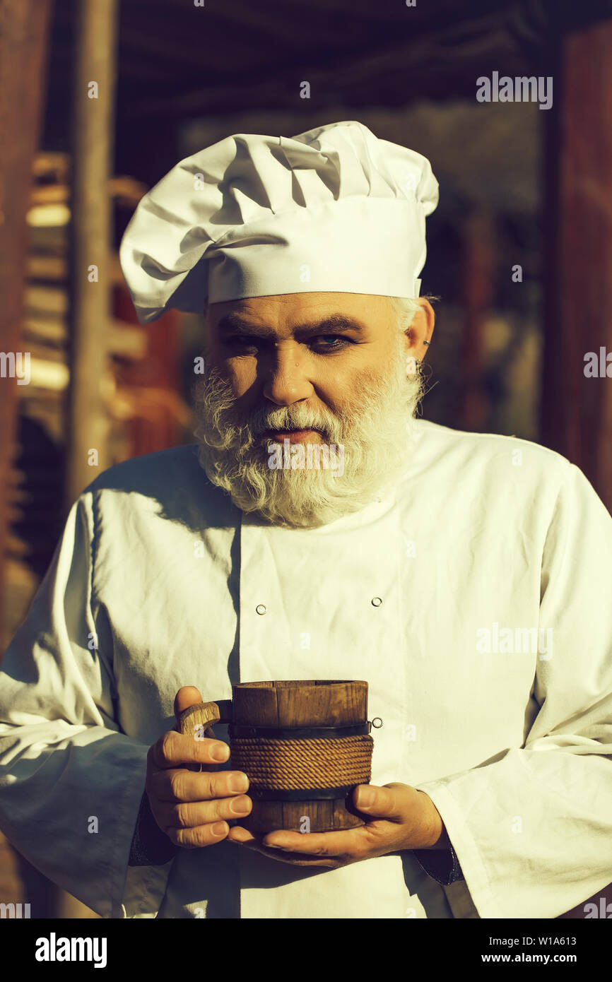 bearded cook with wooden cup Stock Photo - Alamy