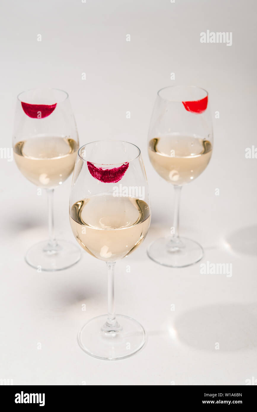 lipstick prints on champagne glasses with alcohol on white Stock Photo