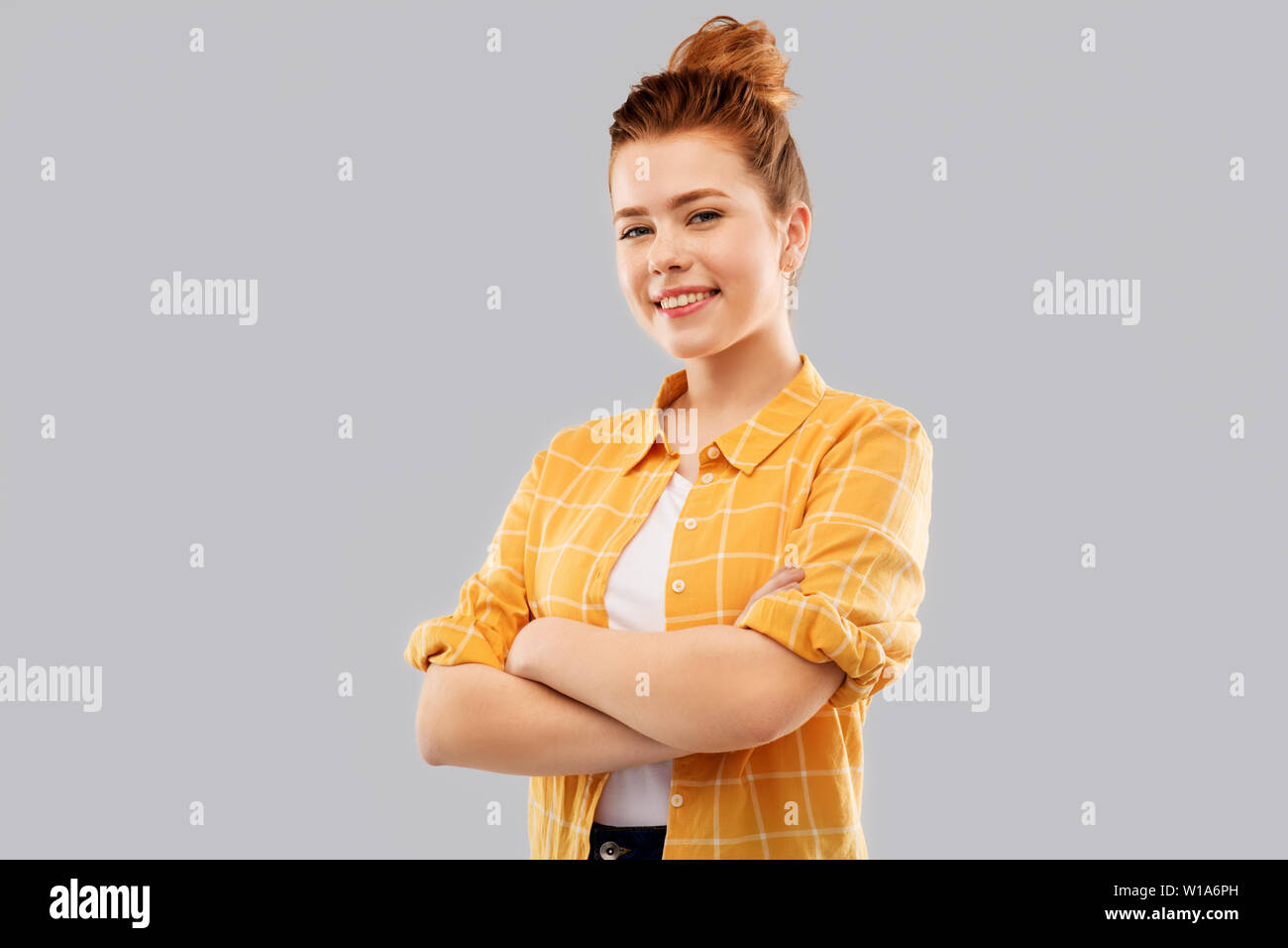 smiling red haired teenage girl with crossed arms Stock Photo