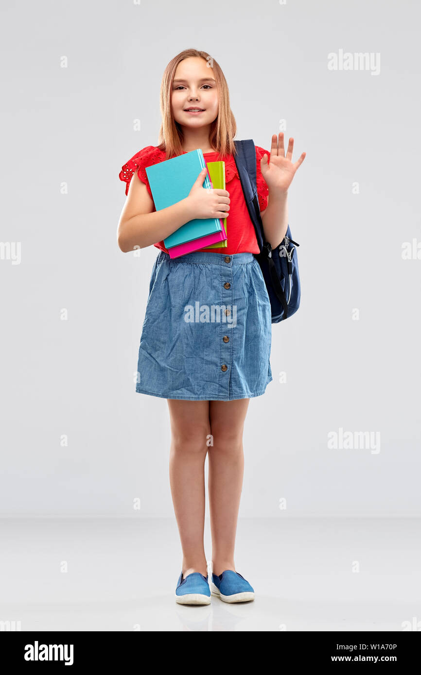 happy student girl with books and bag waving hand Stock Photo - Alamy