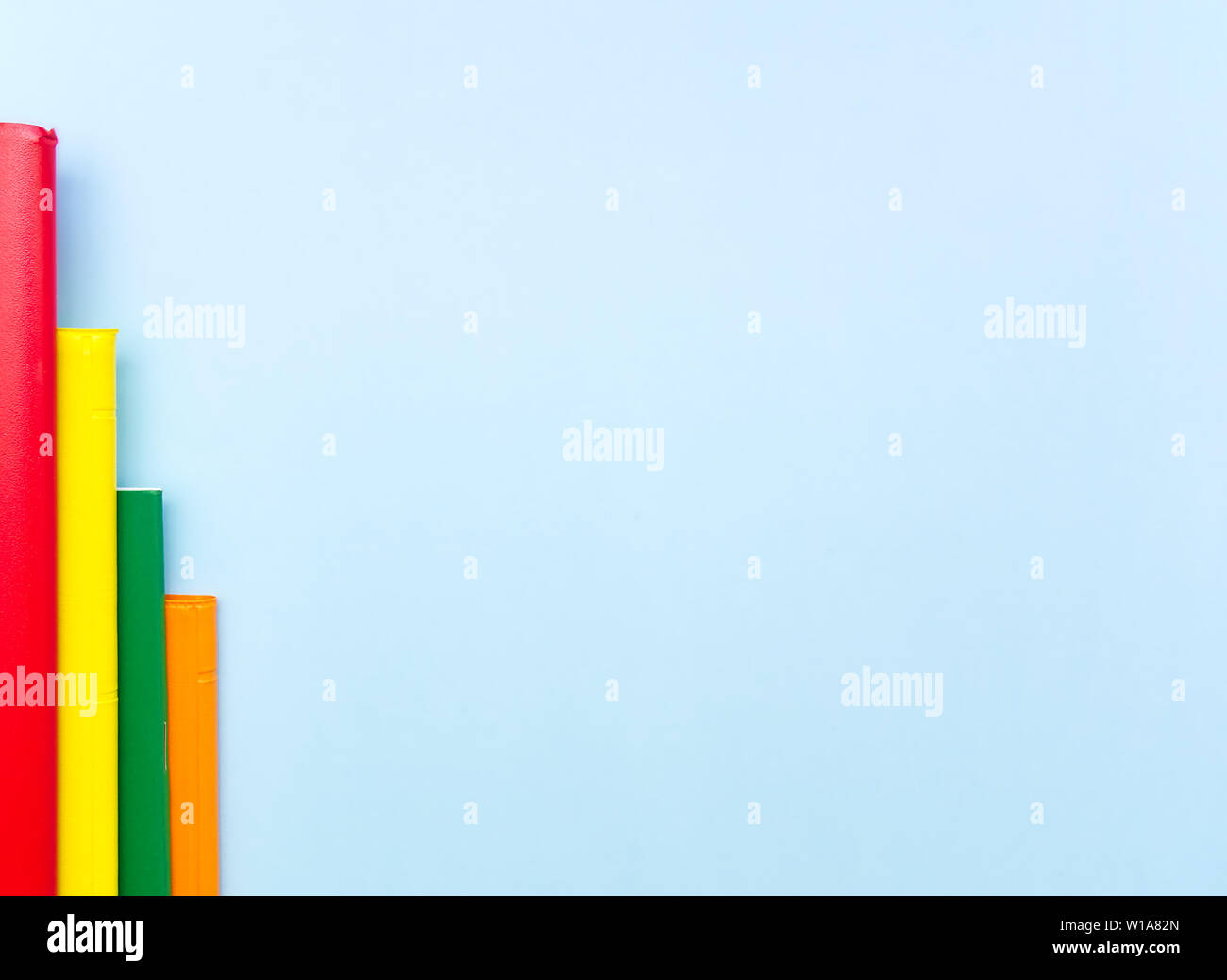 Bar chart made from colorful notebooks on light blue background with empty space for text. Stock Photo