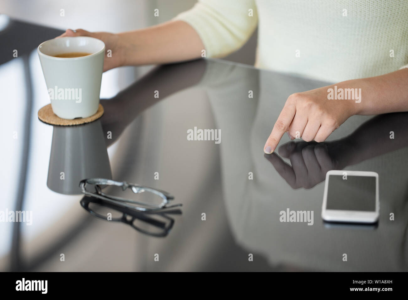 woman with coffee using black interactive panel Stock Photo