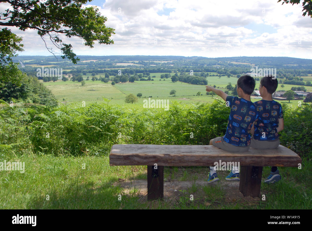 North Downs, Kent / UK. Two children, twin boys enjoying the view from the North Downs Way in Kent. Scenic view of the English countryside in Kent. Stock Photo