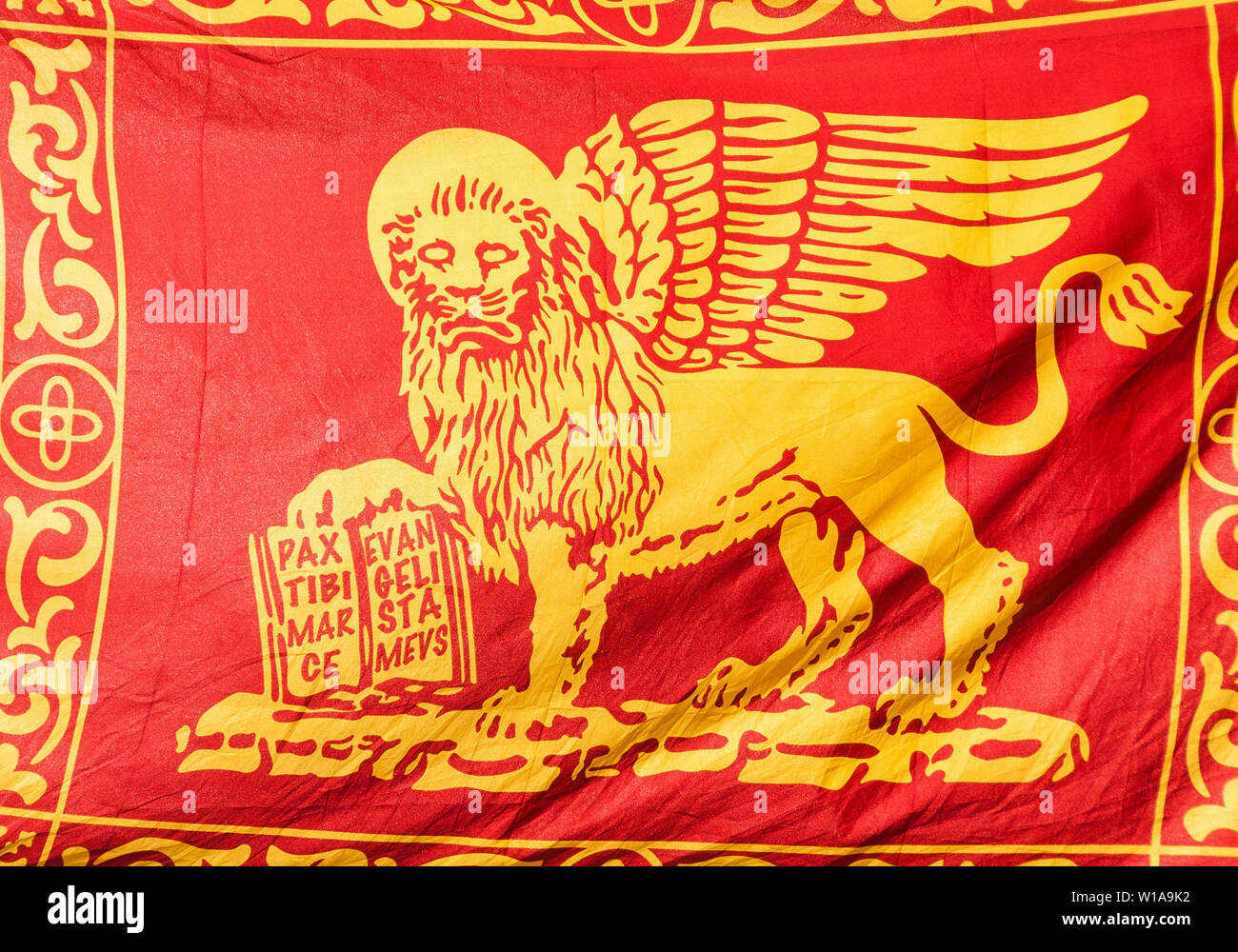 Old Venice Republic Flag with Saint Mark Lion and motto 'Pax tibi Marce, evangelista meus' (Peace be with thee, O Mark, my evangelist) as background Stock Photo