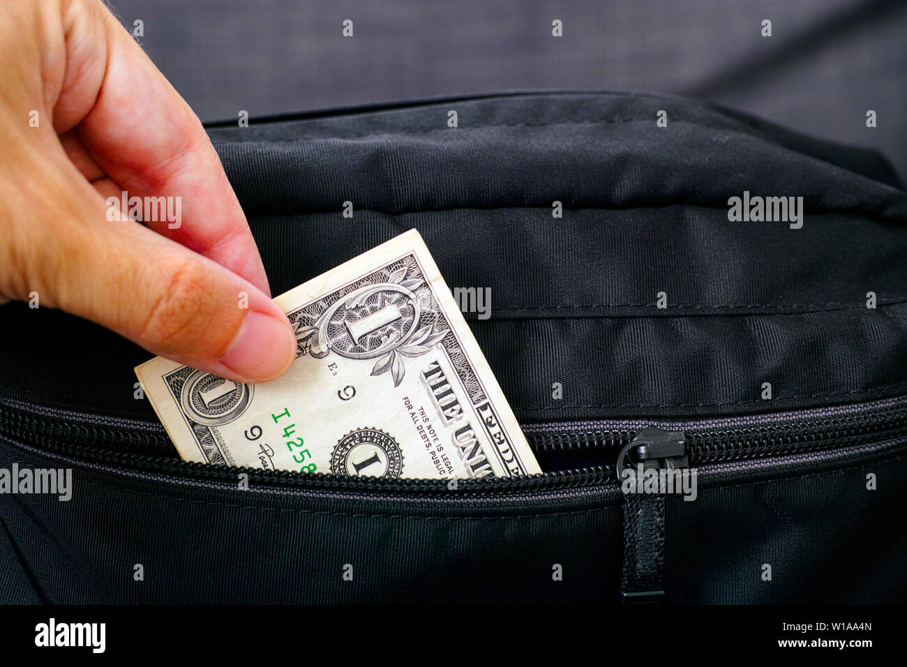 Person hand taking out money from black bag. Close up. Stock Photo