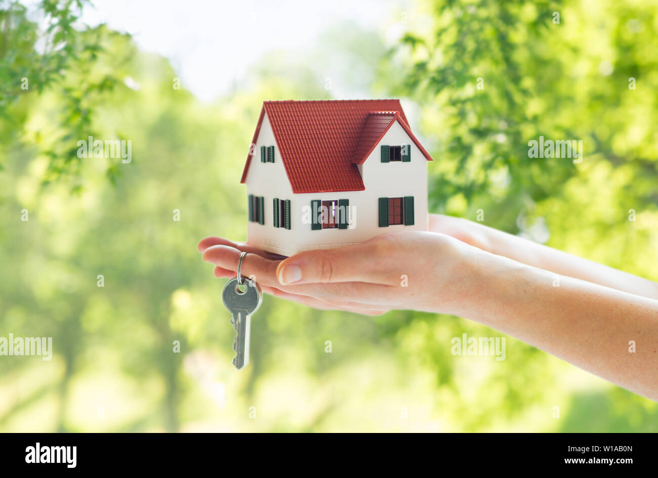 close up of hands holding house model and keys Stock Photo - Alamy